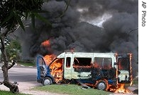 A Congolese police van burns outside the smoldering supreme court building in Kinshasa, Tuesday, Nov. 21, 2006