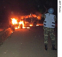 United Nations peacekeepers patrol near a burnt vehicle belonging to UN Mission in the DRC (MONUC) 01 Feb 2007, in Matadi