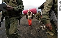 A woman flees to escape fighting between U.N.-backed government forces and renegade troops in the village of Sake in eastern Congo, 28 Nov 2006