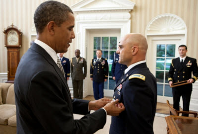 President Barack Obama presents White House Military Aide LTC Barrett Bernard with the Defense Superior Service Medal during a departure ceremony in the Oval Office, Oct. 12, 2011